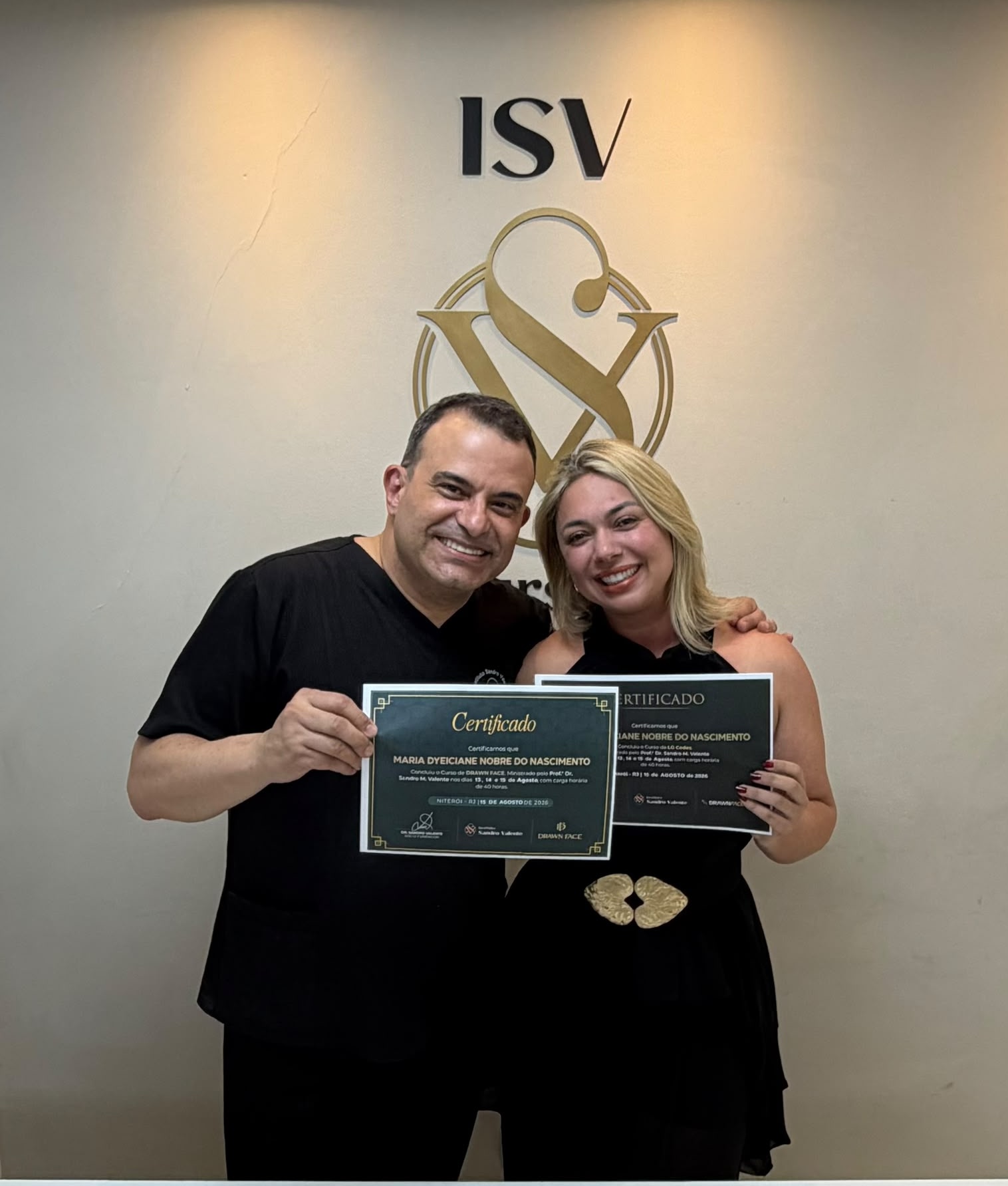 Niterói, agosto de 2026. Dra. Sol com o Prof. Dr. Sandro Valente e o certificado do curso Drawn Face.